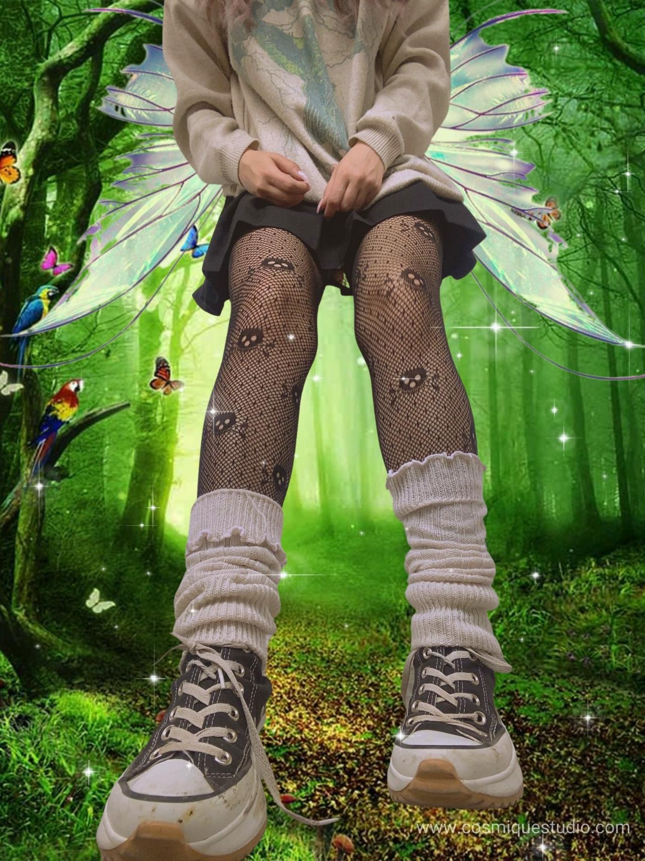 A fairy grunge girl wearing Converse with skull tights, a black skirt and a hoodie, and she is in the forest with butterflies and parrots.