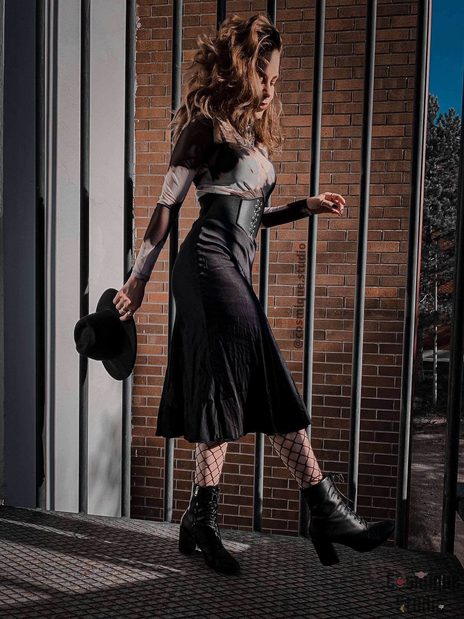 grunge girl in front of bars, wearing black satin midi skirt under animal print tulle blouse combined with black leather corset, fishnet stockings, black fedora hat and a pair of black leather heels 