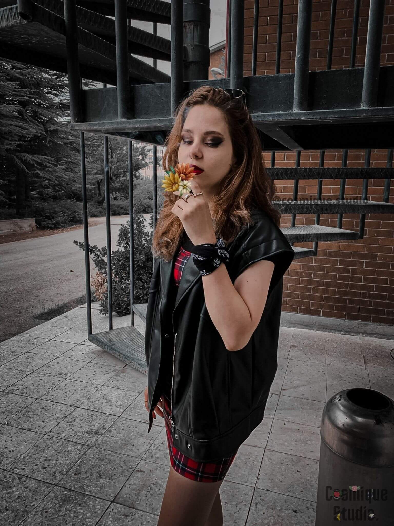 grunge girl under the fire escape wearing black leather sleeveless biker jacket combined with heavy make up